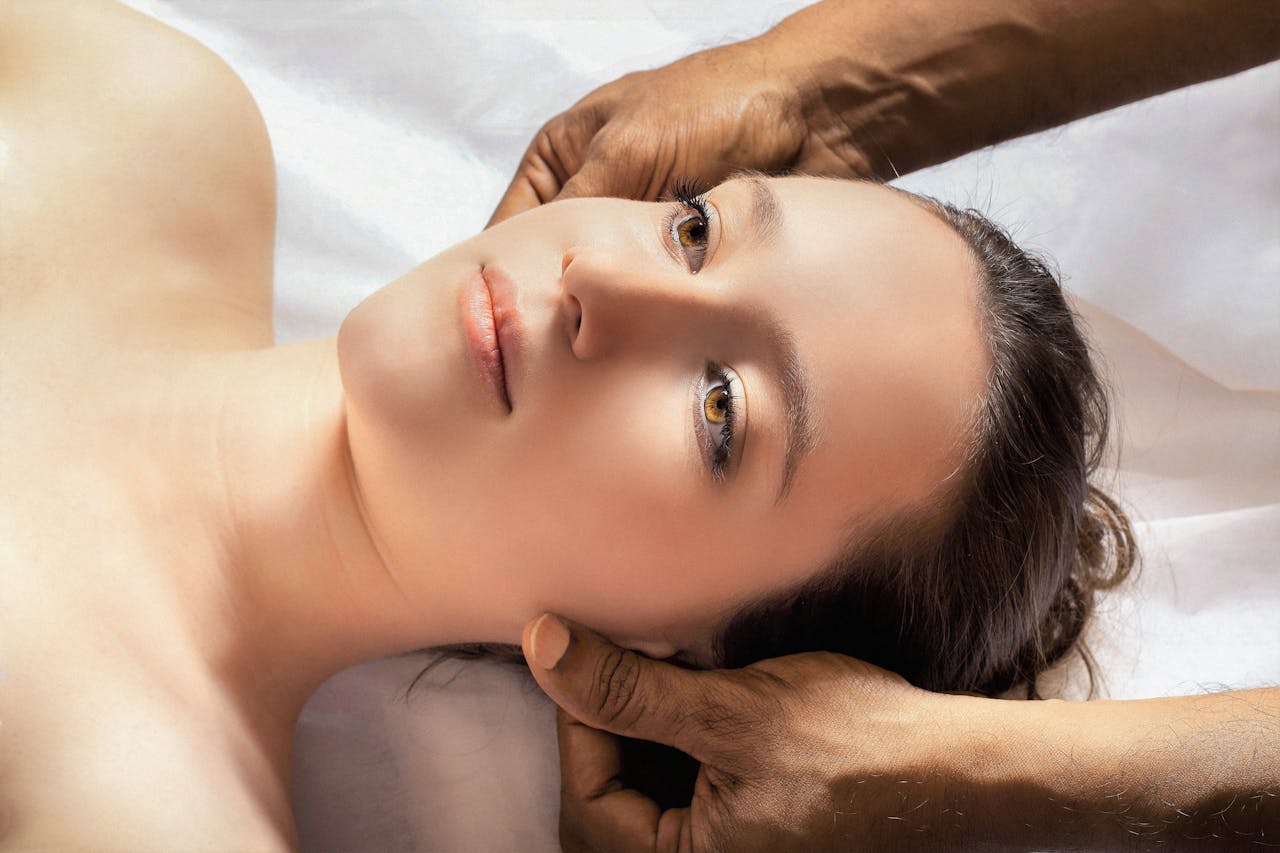 contact-img A calming spa massage session with a young woman receiving a relaxing head massage.